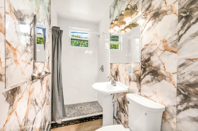 a bathroom with a sink toilet and shower