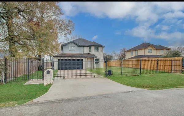 a view of house with a yard and a large tree