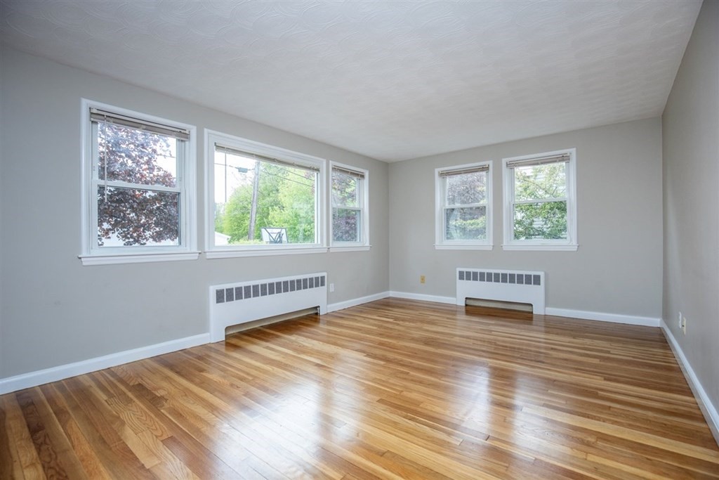 84 Browning Road Arlington, MA 02476 - Photo 5 of 37 a view of an empty room with wooden floor and a window