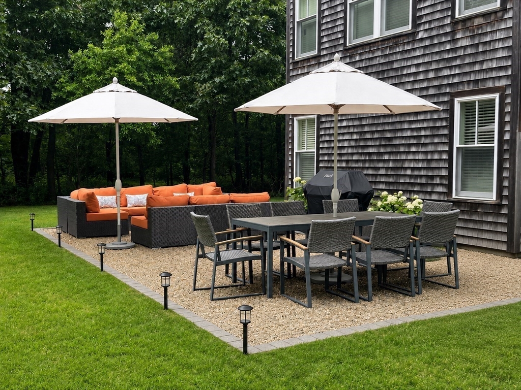13 Young Street Edgartown, MA 02539 - Photo 21 of 29 a view of a tables and chairs under an umbrella