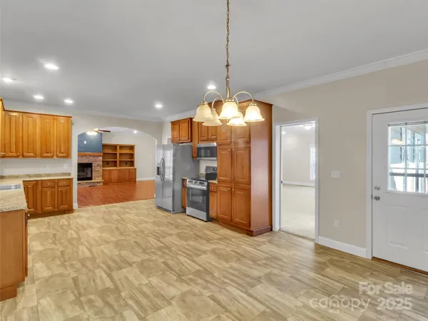 a large kitchen with stainless steel appliances granite countertop a sink and cabinets