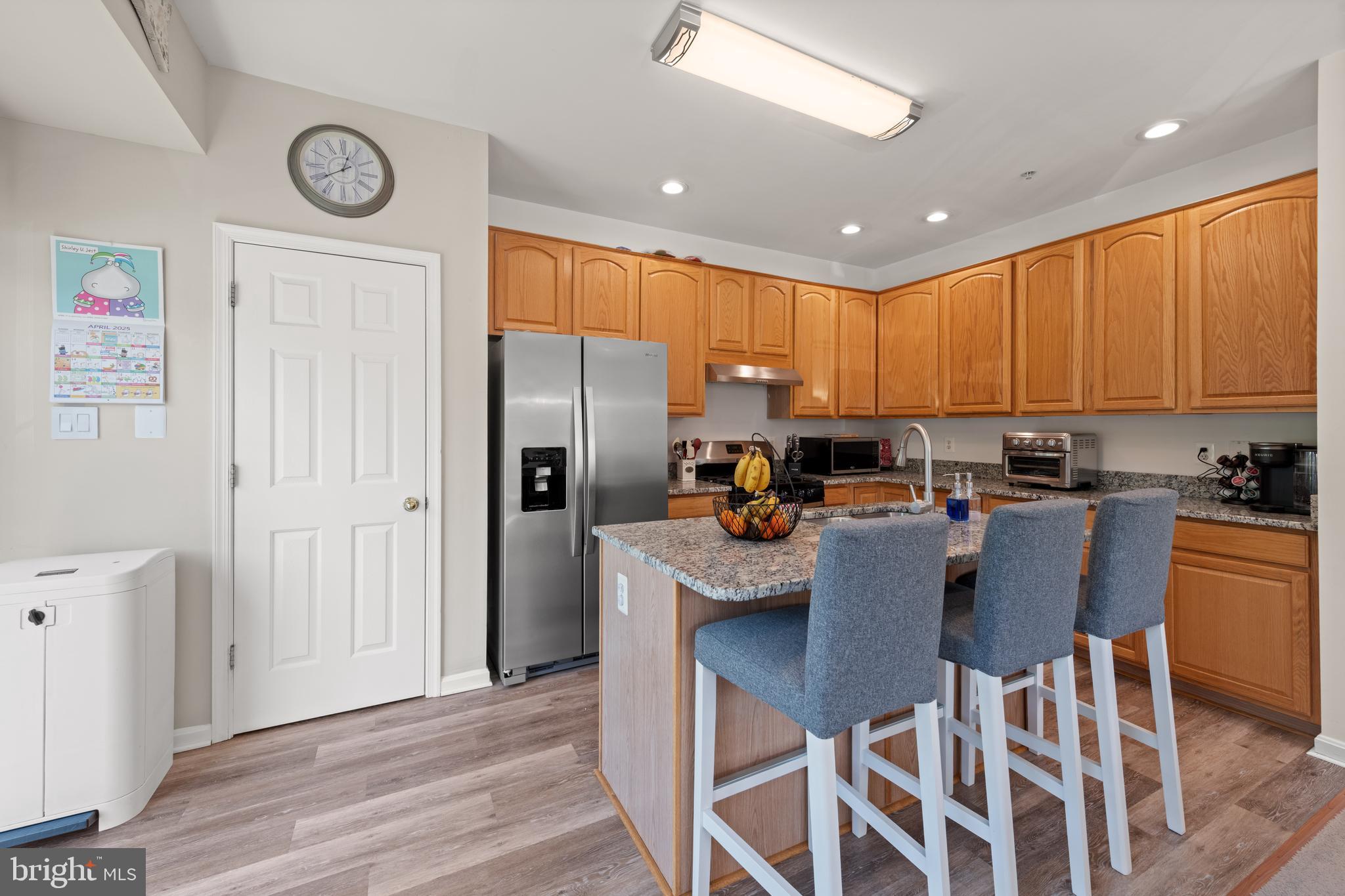 3930 Ballet Way Burtonsville, MD 20866 - Photo 18 of 36 a kitchen with stainless steel appliances granite countertop a refrigerator a sink dishwasher a stove and a dining table with wooden floor