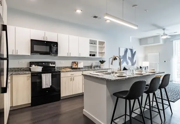 a kitchen with stainless steel appliances kitchen island granite countertop a sink and cabinets