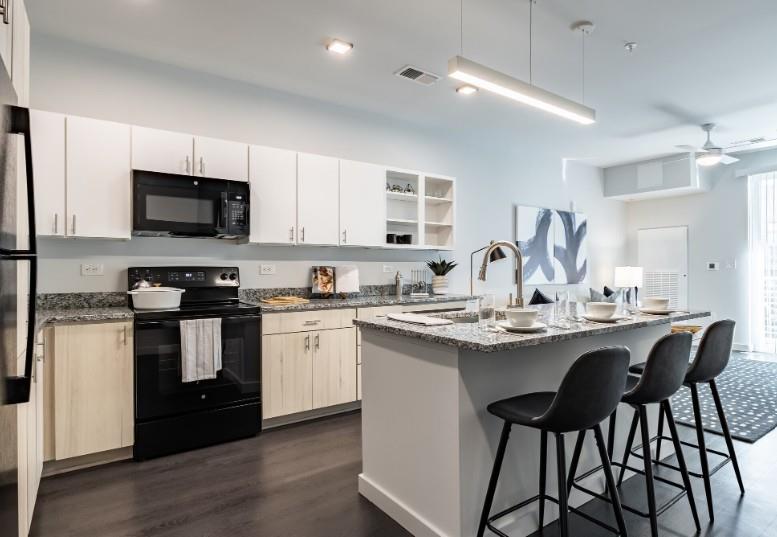 a kitchen with stainless steel appliances kitchen island granite countertop a sink and cabinets