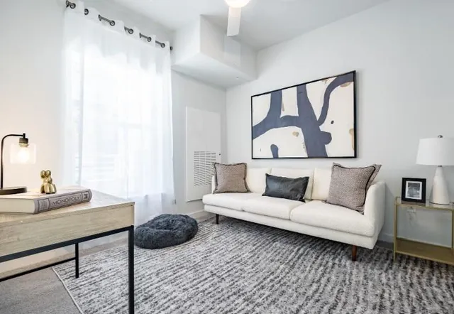 a living room with furniture and a painting on the wall