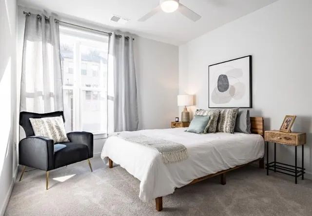 a bedroom with bed couch and window