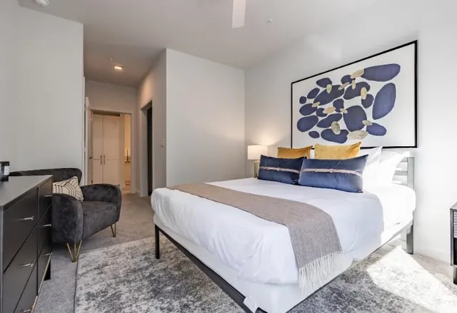 a bedroom with a bed and painting on wall