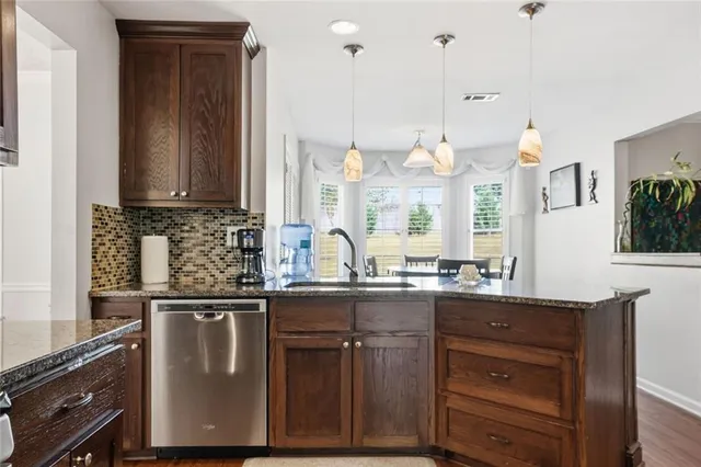 a kitchen with granite countertop a sink a stove and cabinets