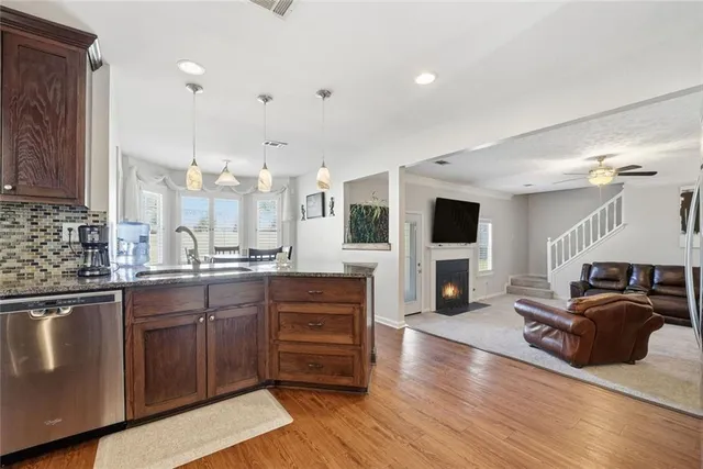 a large kitchen with stainless steel appliances granite countertop a lot of counter space and wooden floor
