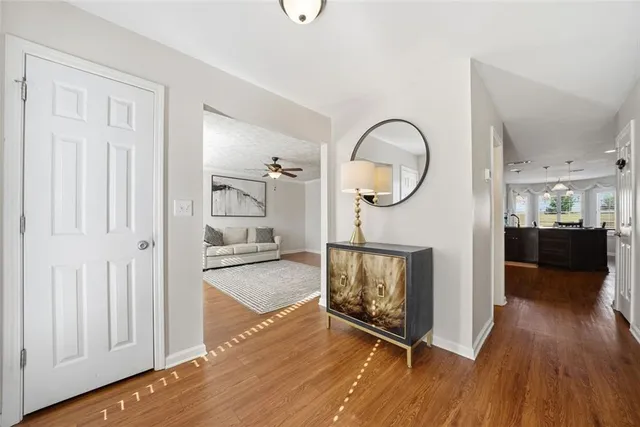a view of a hallway with wooden floor and a bathroom