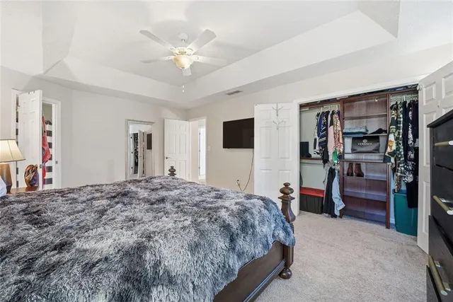a bedroom with a large bed and a ceiling fan