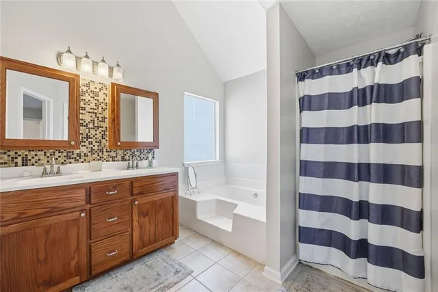a spacious bathroom with a shower a sink and a mirror