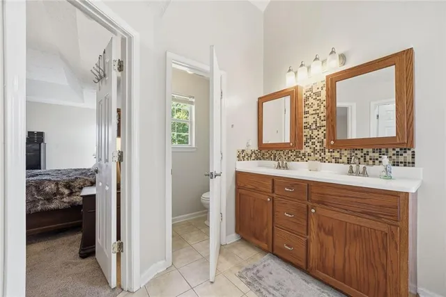 a en suite bathroom with a double vanity sink a mirror and a shower