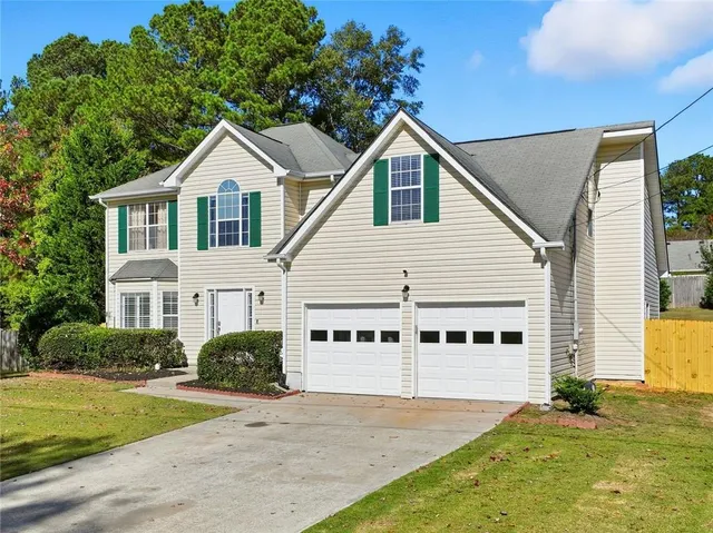 a view of a white house with yard and plants