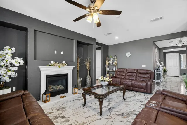 a living room with furniture a ceiling fan and a rug