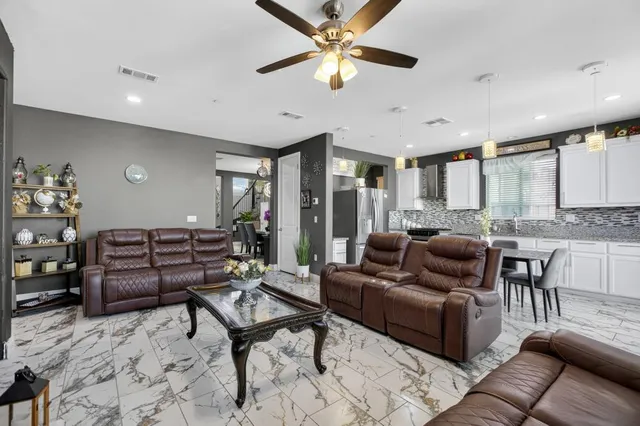 a kitchen with stainless steel appliances granite countertop a stove a sink dishwasher a refrigerator and white cabinets with wooden floor