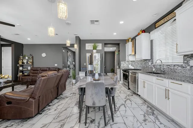 a kitchen with granite countertop a stove sink and cabinets