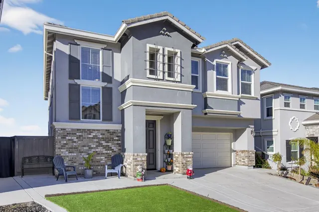 a front view of a house with yard and parking