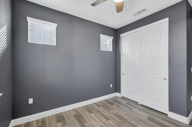 a spacious bedroom with a bed a dresser and chandelier