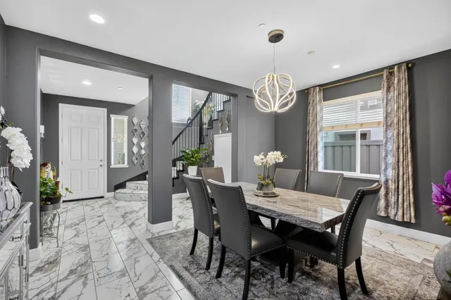 a dining room with furniture a chandelier and wooden floor