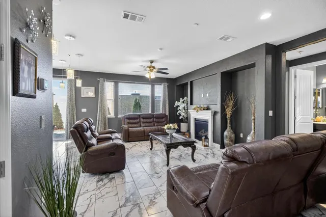a living room with furniture a fireplace and a chandelier