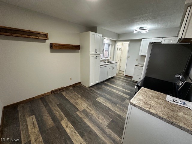 586 Ingalls Road Akron, OH 44312 - Photo 16 of 21 Kitchen with white cabinetry, dark wood-type flooring, light countertops, and a textured ceiling