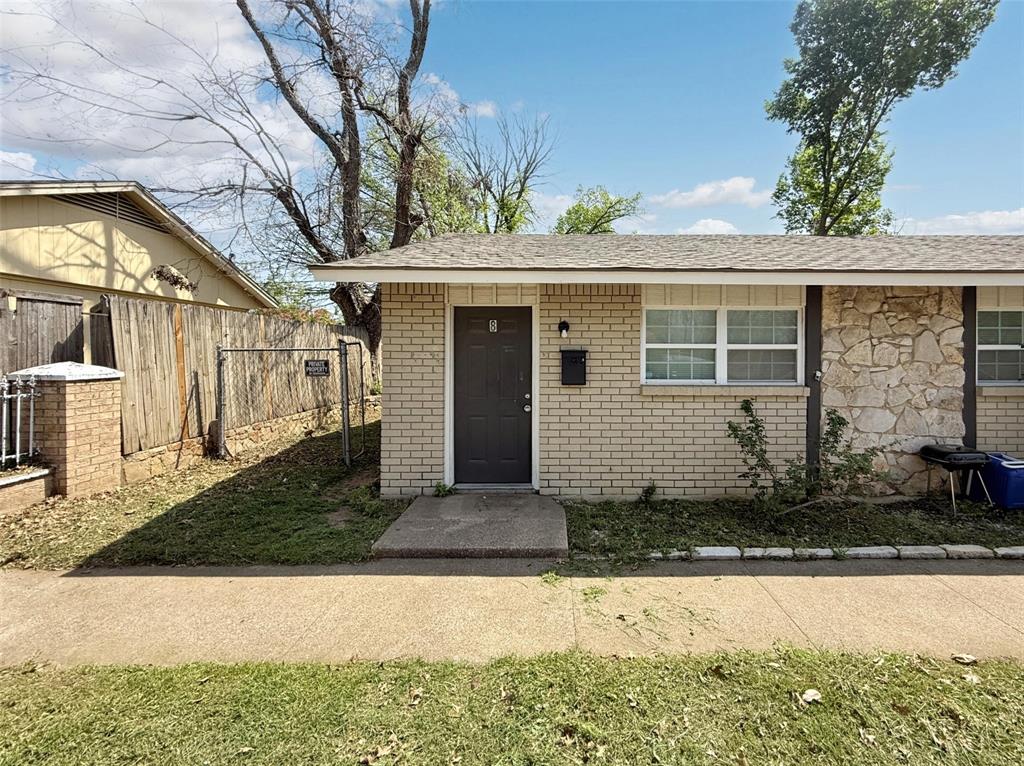 211 Skyway Drive, Unit 8 Euless, TX 76040 - Photo 1 of 1 View of front of house with brick siding, fence, and a shingled roof