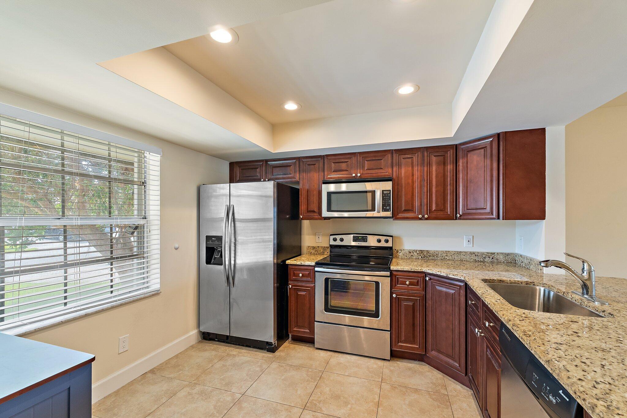 109 Doe Trail Jupiter, FL 33458 - Photo 4 of 26 a kitchen with stainless steel appliances granite countertop a refrigerator stove and sink