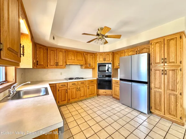 a kitchen with stainless steel appliances granite countertop a refrigerator a sink and a stove
