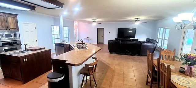 a kitchen with a stove a refrigerator and a dining table with wooden floor