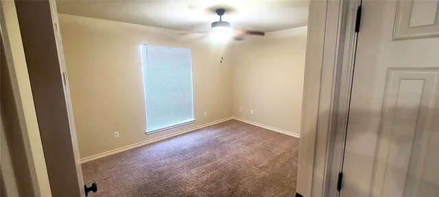 an empty room with fan and entrance