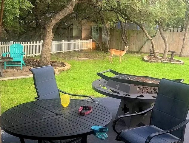 a view of a patio with table and chairs with wooden floor and fence