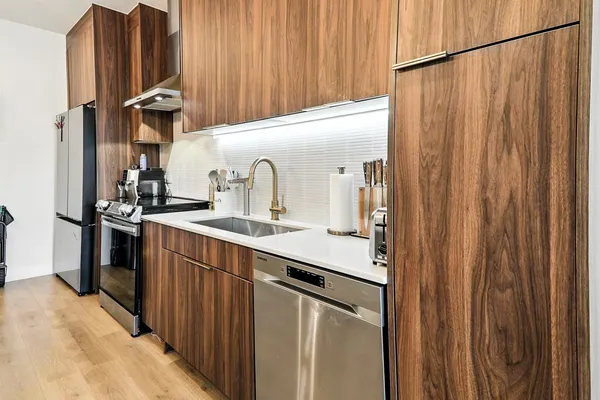 a kitchen with stainless steel appliances a sink and a refrigerator