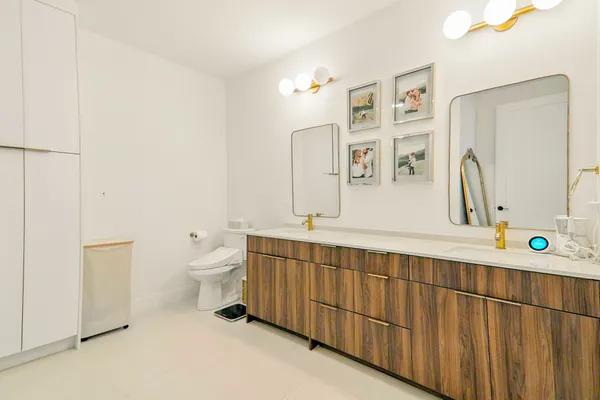 a spacious bathroom with a double vanity sink mirror and toilet