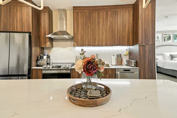 a kitchen with stainless steel appliances a table and chair