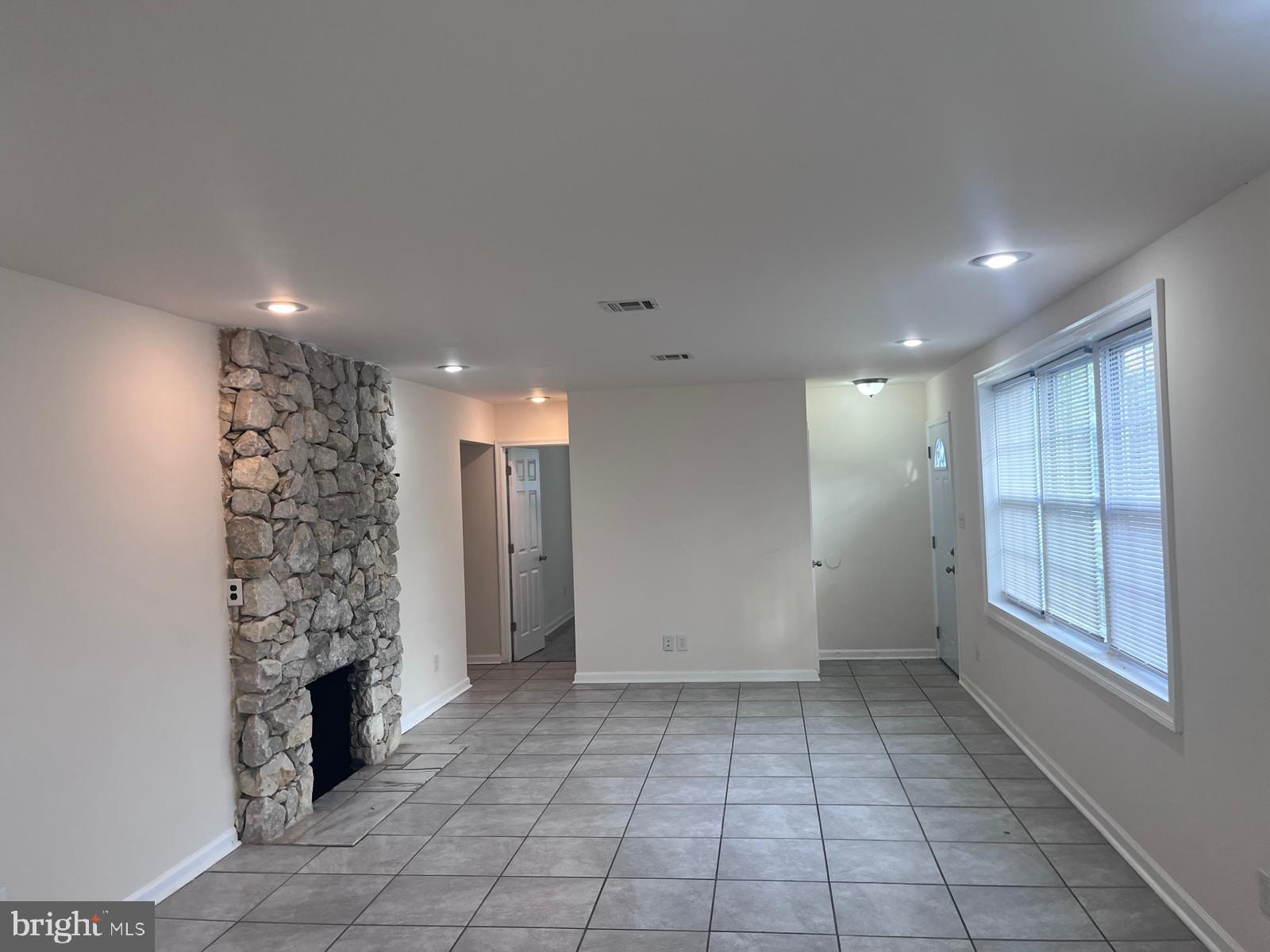 8617 Woodyard Road Clinton, MD 20735 - Photo 13 of 51 wooden floor in an empty room with a fireplace
