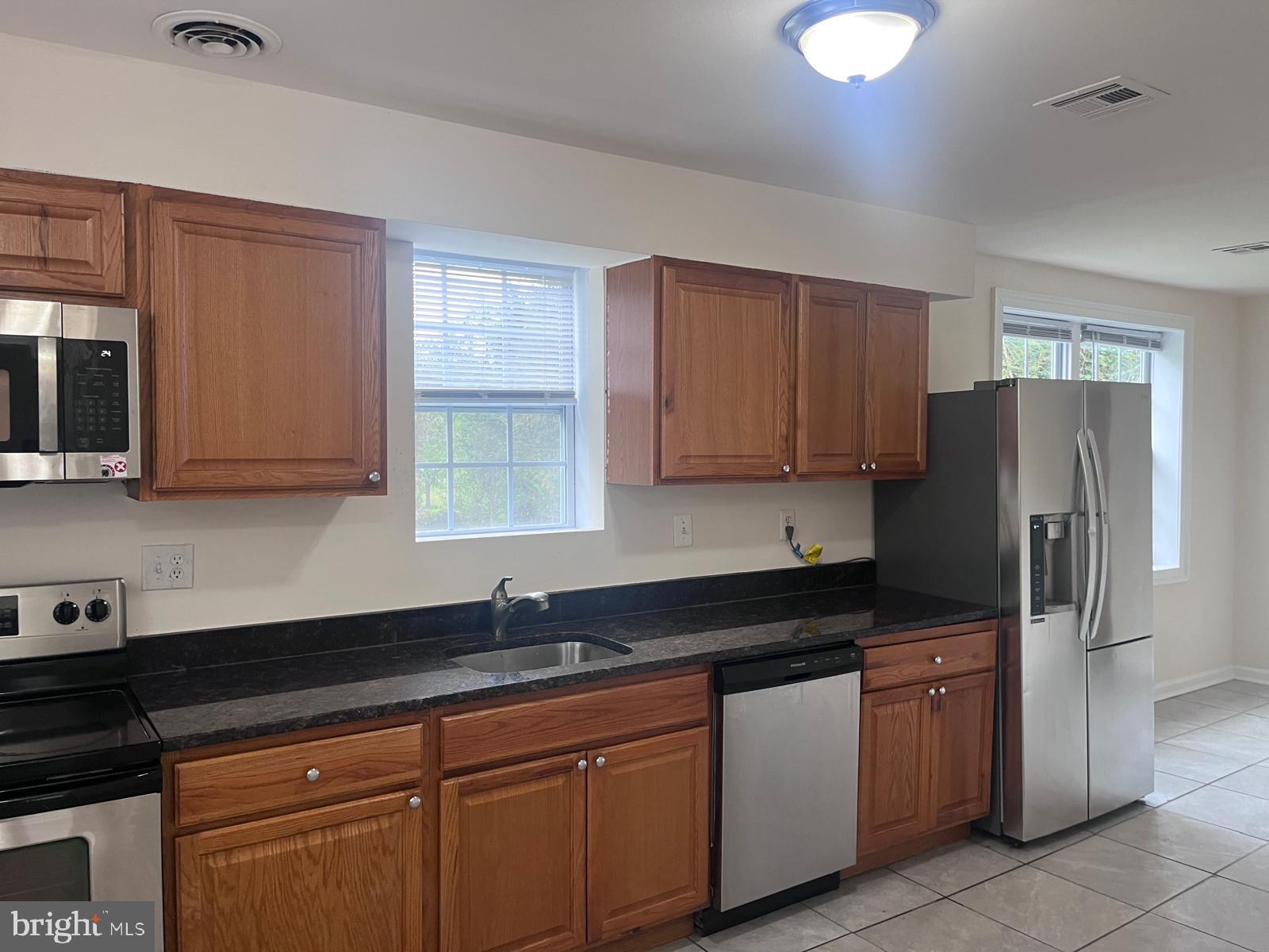 8617 Woodyard Road Clinton, MD 20735 - Photo 16 of 51 a kitchen with stainless steel appliances granite countertop a refrigerator sink and cabinets