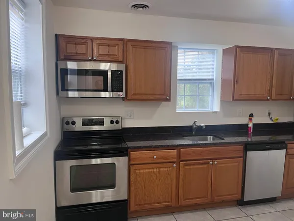 a kitchen with stainless steel appliances granite countertop a stove microwave and cabinets