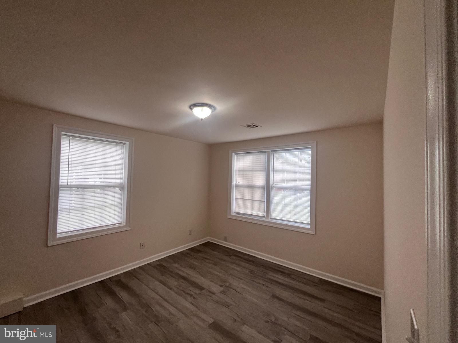 8617 Woodyard Road Clinton, MD 20735 - Photo 23 of 51 an empty room with wooden floor and windows