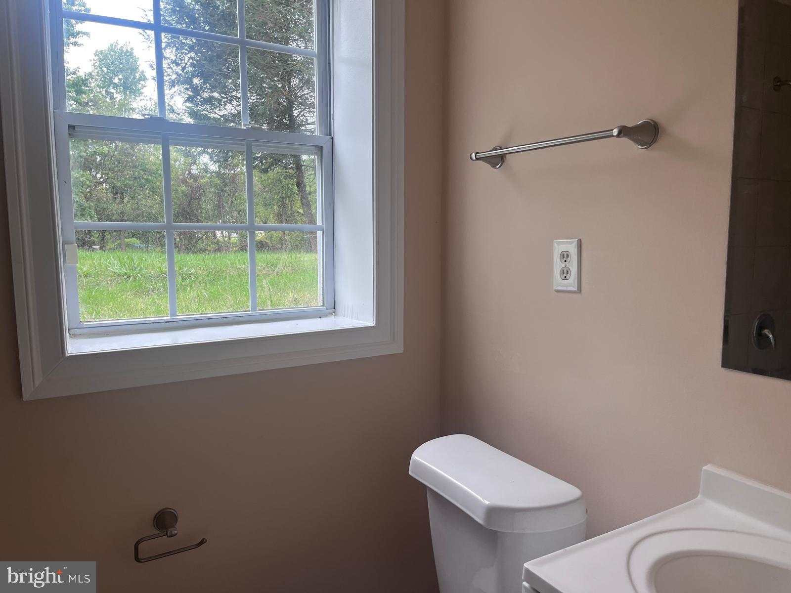 8617 Woodyard Road Clinton, MD 20735 - Photo 34 of 51 a white toilet sitting next to a window in a bathroom