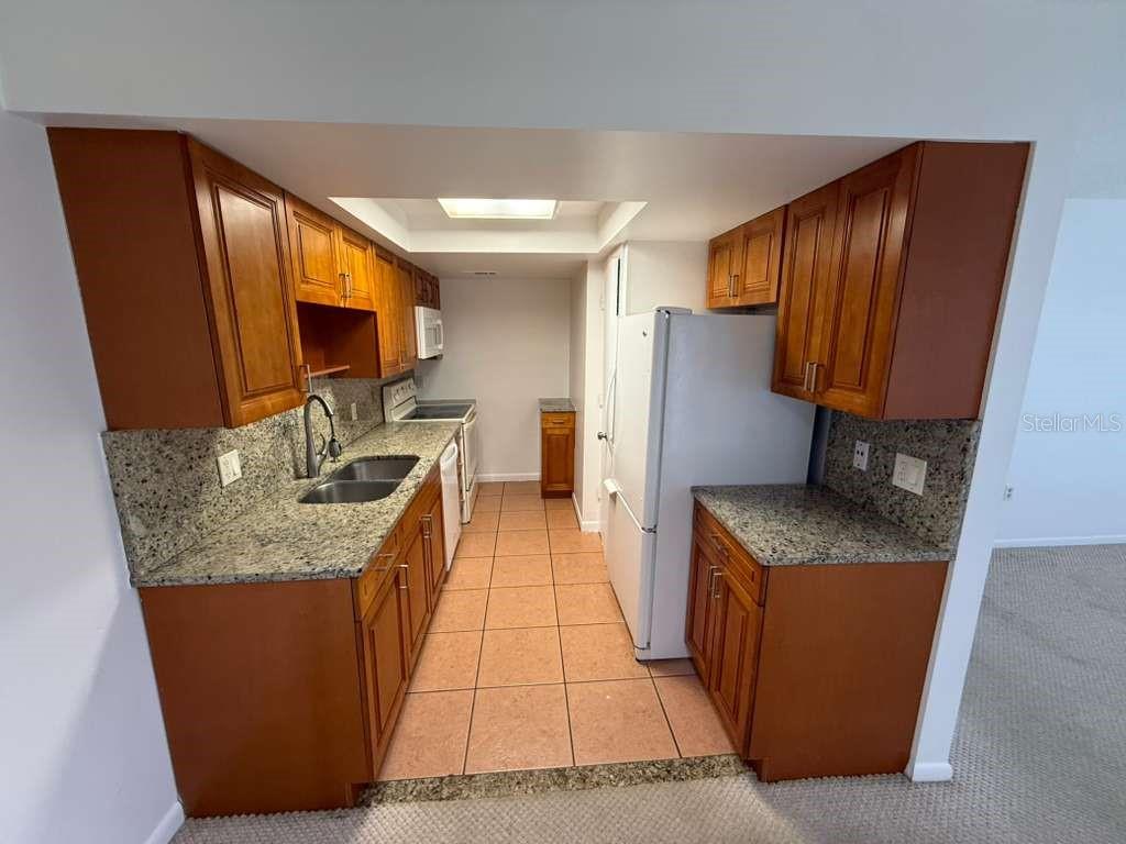 5333 Vineland Road, Unit 101 Orlando, FL 32811 - Photo 7 of 19 a kitchen with stainless steel appliances granite countertop a sink stove and refrigerator