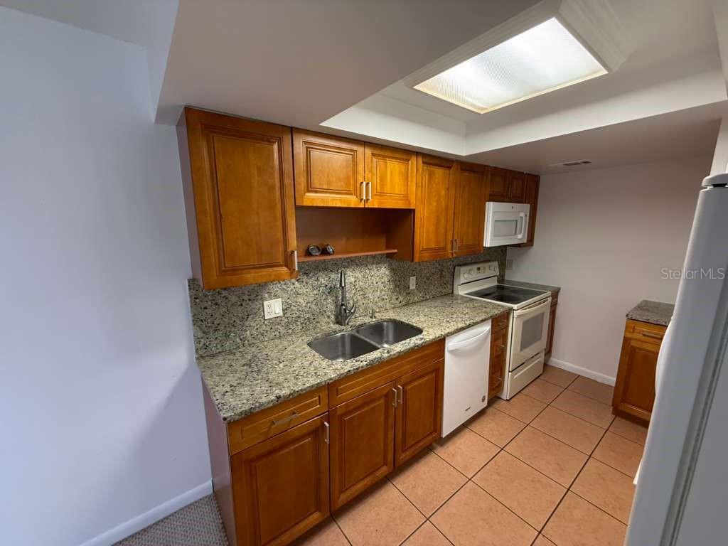 5333 Vineland Road, Unit 101 Orlando, FL 32811 - Photo 9 of 19 a kitchen with a sink a stove and cabinets
