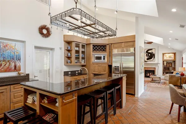 a open kitchen with stainless steel appliances granite countertop a stove and a refrigerator