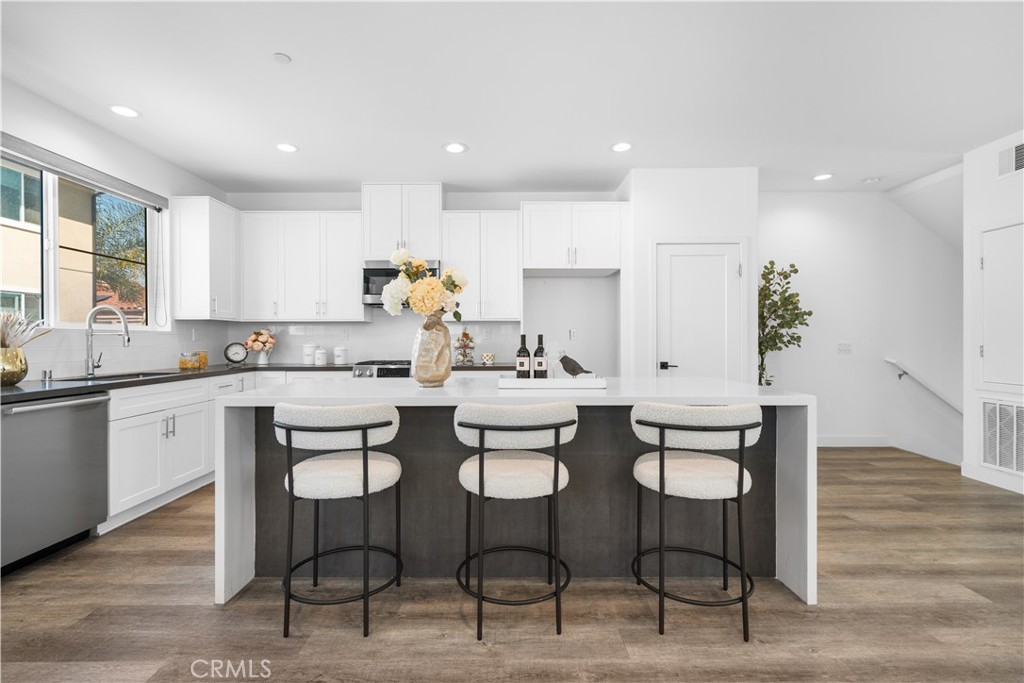23238 Marigold Avenue Torrance, CA 90502 - Photo 12 of 38 a kitchen with white cabinets and chairs