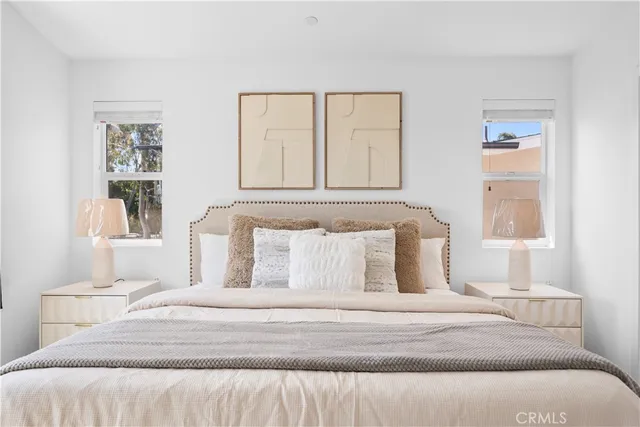 a spacious bedroom with a bed and a potted plant