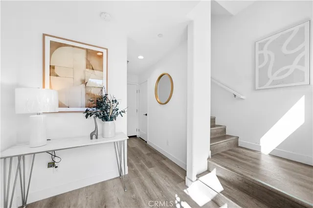 a view of a hallway with wooden floor and entryway