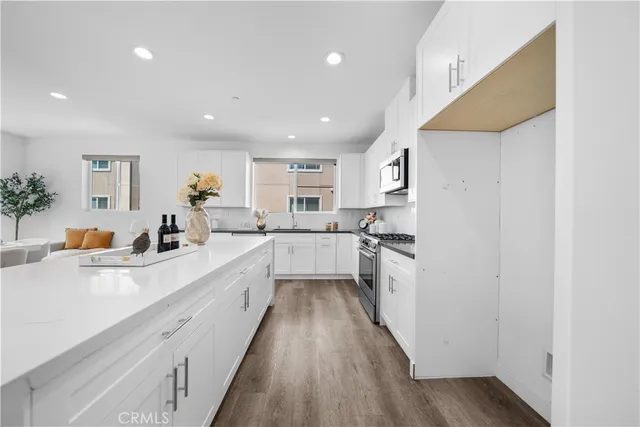 a large kitchen with stainless steel appliances lots of counter space and a sink