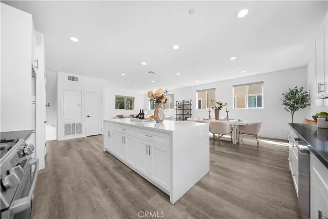 a large white kitchen with lots of counter space and furniture