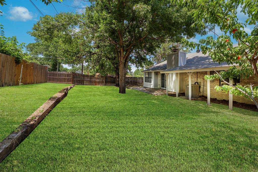 617 Rolling Ridge Court Azle, TX 76020 - Photo 15 of 20 Expansive backyard featuring a manicured lawn, established shade trees, a covered patio with support columns, a brick exterior, and a privacy fence