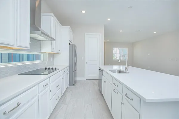 a large white kitchen with a large window